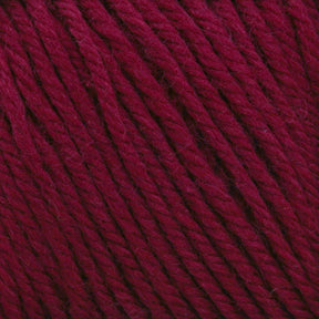 Close-up of Cascade 220 Superwash Wool Yarn in burgundy, showcasing its twist and texture. The rich, deep red 100% merino wool fibers are tightly wound, highlighting the intricate details and beautiful stitch definition. The yarn appears soft and thick, suitable for knitting or crocheting.