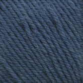 Close-up of Cascade 220 Superwash Wool Yarn in deep blue from Cascade Yarns. The image showcases tightly spun fibers, emphasizing the texture and slight fuzziness of the 100% merino wool material. The uniformly thick and even strands form a coiled pattern, ensuring beautiful stitch definition.