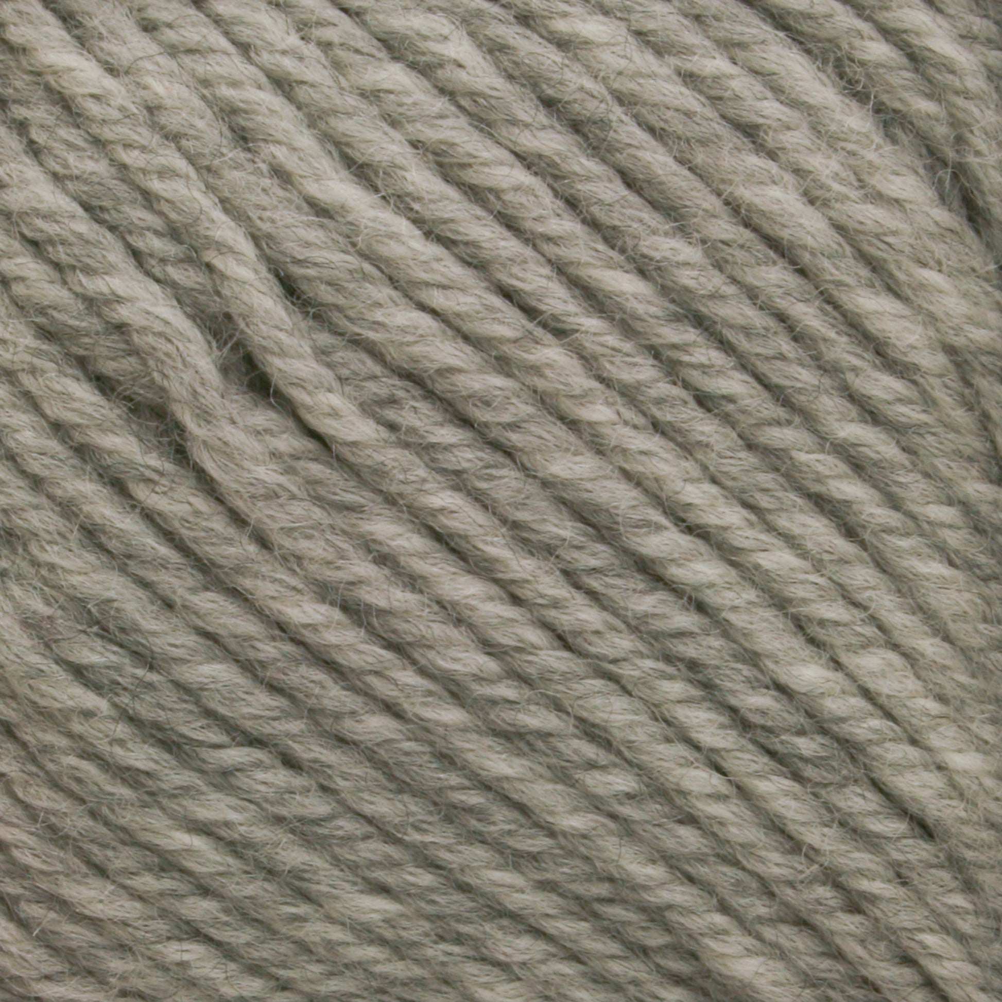 Close-up image of grey Cascade 220 Superwash Wool Yarn from Cascade Yarns, showing its texture and tightly twisted strands. The superwash DK weight yarn appears soft and is made from 100% merino wool. It is evenly spun, ideal for knitting or crocheting projects with beautiful stitch definition.