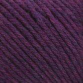 Close-up of a ball of Cascade 220 Superwash Wool Yarn from Cascade Yarns in DK weight, featuring an exquisite mix of purples and dark pinks. This 100% merino wool yarn showcases a soft, textured appearance with clearly visible individual strands. The blend of colors creates a rich, multi-tonal effect with beautiful stitch definition.