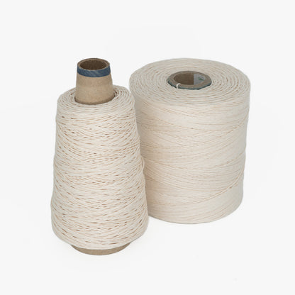 Two spools of 20/6 Linen Rug Lacing in Natural White from Stuart C. Hurlbert & Co. are shown against a plain white background. The spool on the left is cone-shaped, while the spool on the right is cylindrical. Both spools have tightly woven thread, reminiscent of linen quality, neatly wound around them.