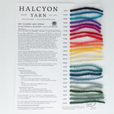 The Classic Rug Wool Sample Card from Halcyon Yarn features 14 strands of Halcyon Classic Rug Wools in vibrant shades, each labeled with a color name and number. The text provides product specifications such as fiber content, yardage, and recommended knitting needle sizes for this quality, colorfast wool.