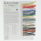 The Peace Fleece Sample Card by Halcyon Yarn features 20 distinct yarn samples, ranging from earthy tones like white and yellow to an array of blues, greens, reds, and oranges, as well as grays and black. Each sample is labeled with a specific code, and the text on the card provides product information including options such as tweeds and Peace Fleece.