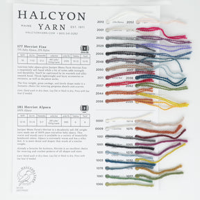 A Juniper Moon Herriot Fine & Herriot Alpaca Sample Card for Halcyon Yarn, showcasing various yarn types and colors. The left side lists details for "177 Herriot Fine" and "181 Herriot Baby Alpaca," while the right side displays strands of luxurious alpaca yarn in different shades, each labeled with a number for knitters and crocheters to easily identify.