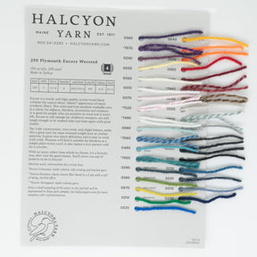 A color chart from Halcyon Yarn showcasing 36 yarn samples in a range of colors and textures, including the versatile Plymouth Encore Worsted Yarn, attached to a grey background. Each sample is uniquely labeled with a reference number. The company name and details are printed at the top with a logo in the bottom left corner.