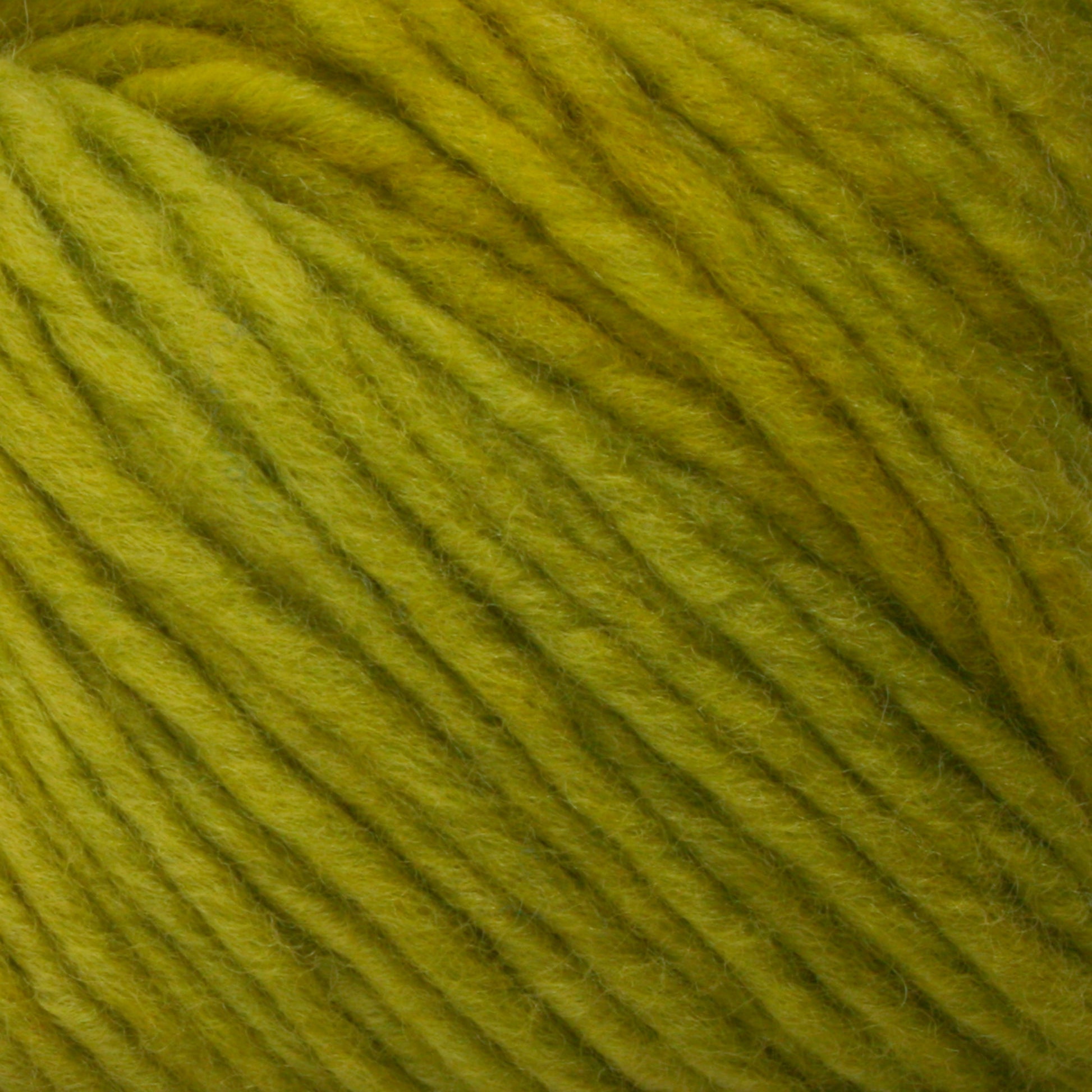 Close-up of a ball of yellow-green Malabrigo Merino Worsted Wool Yarn by Malabrigo Yarn, featuring tightly woven strands with slight flecks of darker yellow-green. The texture appears soft and slightly fuzzy, ideal for knitting or crocheting projects. This worsted weight gauge yarn is perfect for cozy garments and accessories.