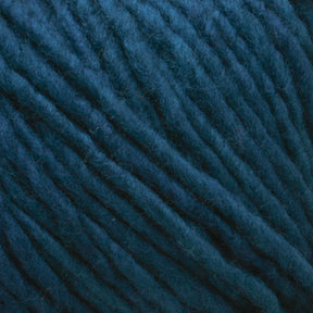 Close-up image of soft, bulky Malabrigo Merino Worsted Wool Yarn in a deep, rich teal color. The kettle-dyed strands are thick and slightly fuzzy, tightly interwoven in parallel lines to create a textured surface. The lighting emphasizes the yarn's rich hue and soft texture, perfect for a worsted weight gauge project from Malabrigo Yarn.