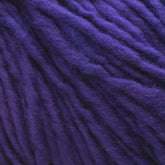 Close-up of thick strands of deep purple Malabrigo Merino Worsted Wool Yarn by Malabrigo Yarn. The texture is fuzzy, with interwoven fibers clearly visible, creating a plush appearance. The rich color and soft texture suggest the yarn would be ideal for cozy knitting projects requiring worsted weight gauge.