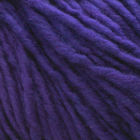 Close-up of thick strands of deep purple Malabrigo Merino Worsted Wool Yarn by Malabrigo Yarn. The texture is fuzzy, with interwoven fibers clearly visible, creating a plush appearance. The rich color and soft texture suggest the yarn would be ideal for cozy knitting projects requiring worsted weight gauge.