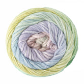 A skein of Cumulus Cotton by Juniper Moon Farm, from Knitting Fever / Euro Yarns, features soft, durable yarn in a tightly wound spiral with rainbow hues merging smoothly from pastel yellow to green, blue, lavender, pink, and cream for a textured look.