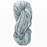 A skein of Cumulus Cotton by Juniper Moon Farm, featuring blue and white variegated yarn, is twisted into a braid-like shape against a white background. Offered by Knitting Fever / Euro Yarns, this durable cotton appears soft and textured with shades ranging from light to dark.