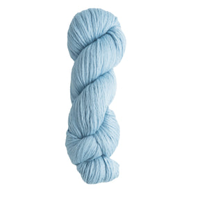 Against a white background lies a twisted skein of Cumulus Cotton, soft pastel blue yarn made from durable cotton by Juniper Moon Farm, available through Knitting Fever / Euro Yarns.