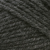 Close-up image of Plymouth Encore Worsted Yarn by Plymouth Yarn Co., featuring a dark gray, worsted weight with a tightly twisted texture and light fibers interspersed throughout. This thick and sturdy yarn is perfect for knitting or crocheting projects and offers an economical, machine washable option for crafters.