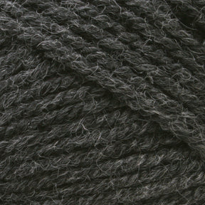 Close-up image of Plymouth Encore Worsted Yarn by Plymouth Yarn Co., featuring a dark gray, worsted weight with a tightly twisted texture and light fibers interspersed throughout. This thick and sturdy yarn is perfect for knitting or crocheting projects and offers an economical, machine washable option for crafters.