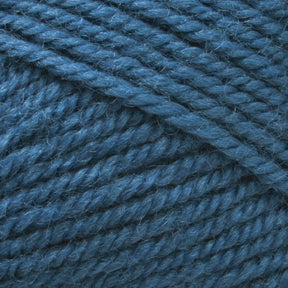 Close-up view of Plymouth Encore Worsted Yarn from Plymouth Yarn Co. in a rich teal blue, wound into a ball. The texture is detailed, showcasing tightly twisted fibers with a slight fuzziness. This soft and thick worsted weight yarn appears perfect for knitting or crocheting, offering an affordable option that is also machine washable.