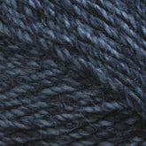 Close-up of Plymouth Encore Worsted Yarn by Plymouth Yarn Co. in a dark blue shade, showcasing its slightly shiny and textured appearance. The strands are tightly twisted together, accentuating the individual fibers and offering a rich, detailed texture. This economical yarn is also machine washable, making it an ideal choice for various projects.