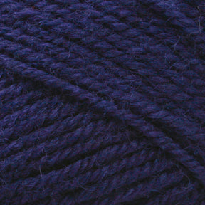 A close-up image of thick, dark purple Plymouth Encore Worsted Yarn from Plymouth Yarn Co. The twisted fibers and textured surface are clearly visible, showcasing the yarn's rich color and intricate weave. This machine washable yarn is an economical option for all your crafting needs.