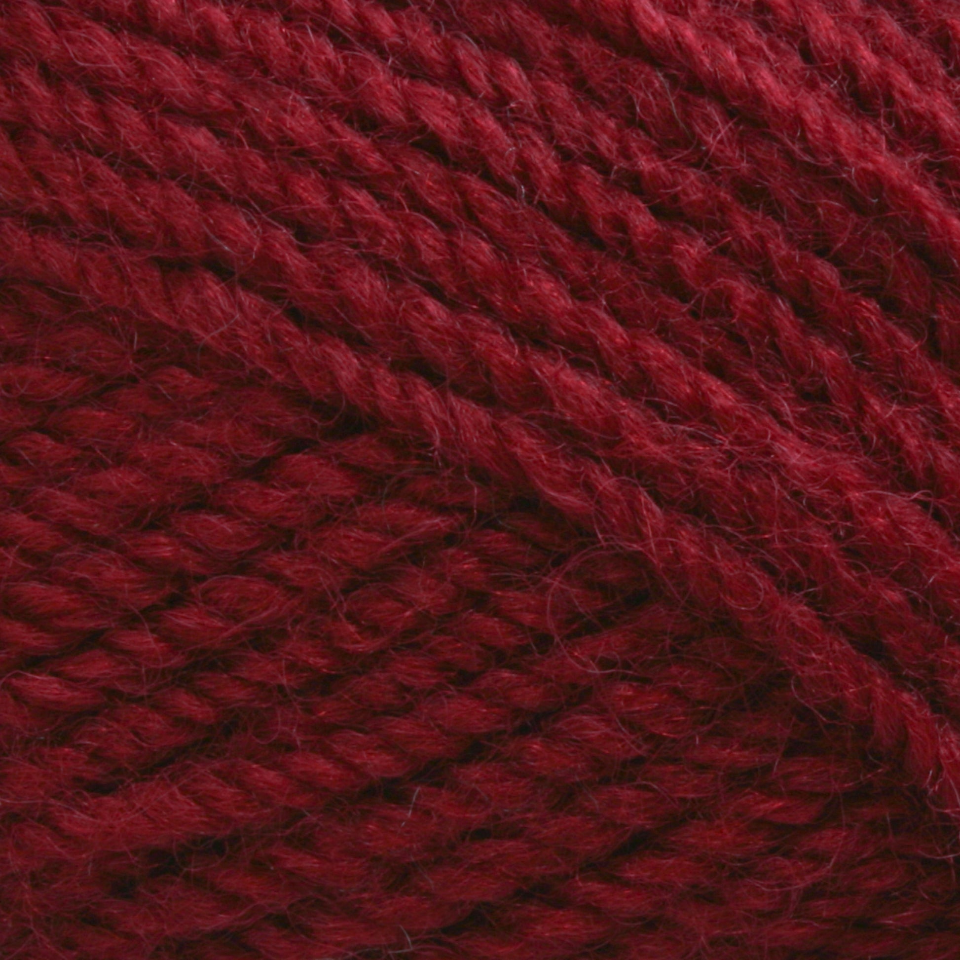 Close-up view of Plymouth Encore Worsted Yarn by Plymouth Yarn Co. in a rich burgundy hue, featuring intricate, tightly woven strands that highlight the machine washable fiber's texture and detail.