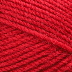 Close-up image of Plymouth Encore Worst Yarn by Plymouth Yarn Co., in red, worsted weight, showcasing the detailed texture of the tightly wound fibers. The yarn appears soft and thick, perfect for knitting or crocheting projects. The vibrant red color is uniform throughout the strands. This economical option is also machine washable for easy care.