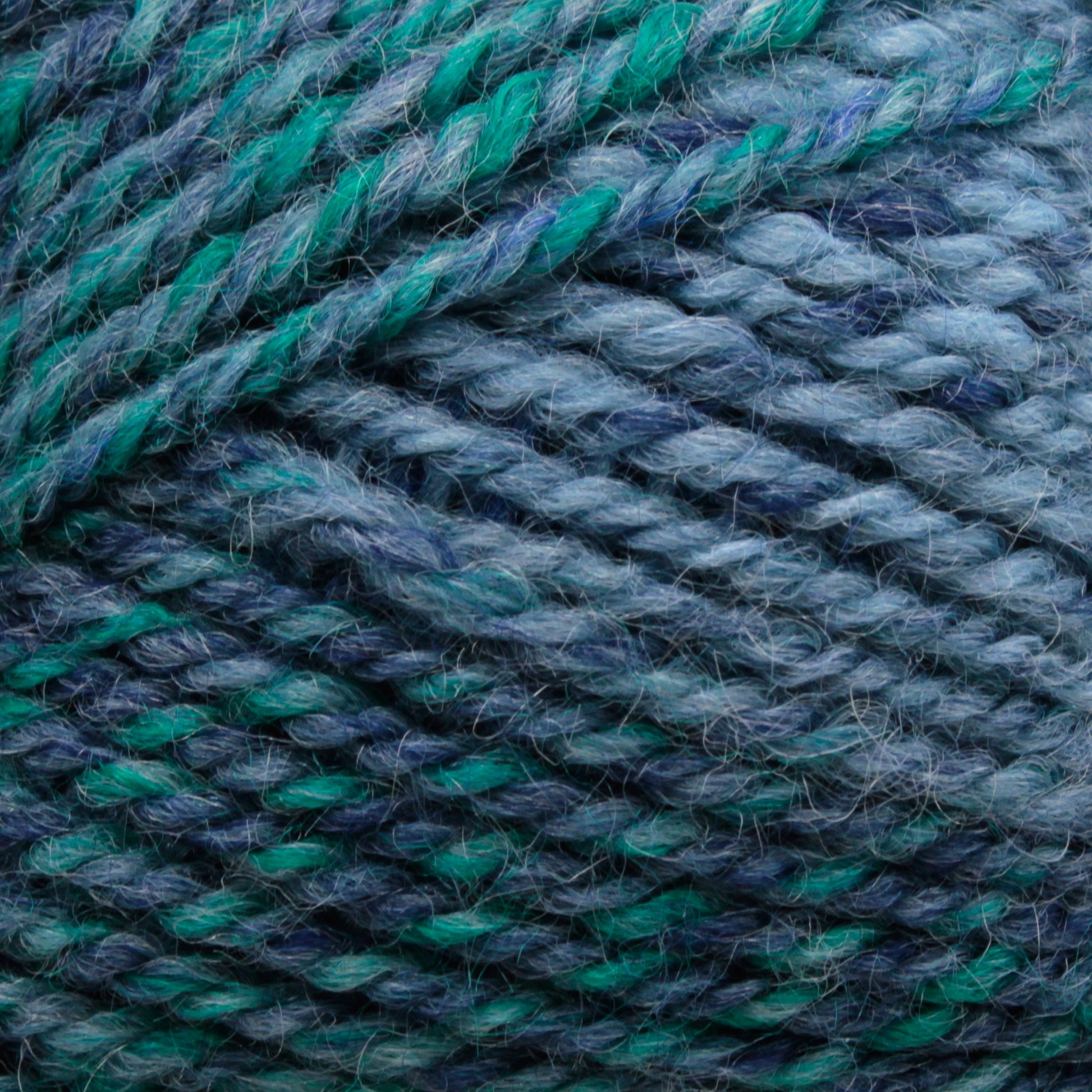 Close-up image of Plymouth Encore Worsted Yarn by Plymouth Yarn Co. in shades of blue and green, showcasing the texture and tight twists of the fibers.