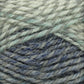 Close-up of a ball of Plymouth Encore Worsted Yarn with varying shades of blue and gray. The fibers are interwoven, creating a textured and cozy appearance. The image highlights the yarn's soft, fuzzy texture, making it ideal for knitting projects and an economical option for crafters from Plymouth Yarn Co.