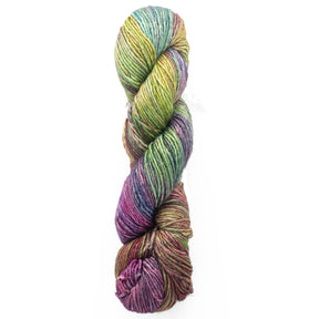 A twisted skein of Malabrigo Silky Merino, this luxury yarn from Malabrigo Yarn showcases a multicolored blend with shades of green, purple, blue, and brown against a white background.