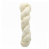 A luxurious skein of Malabrigo Silky Merino by Malabrigo Yarn in a light cream color, expertly twisted, showcases its elegance against a pristine white background.