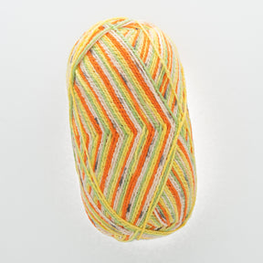 A close-up view of the Regia Cotton Tutti Frutti Color yarn ball from Sirdar - Regia, Schachenmayr & Rowan. The self-striping yarn features vibrant stripes in shades of yellow, orange, green, and cream, creating a visually appealing pattern. The ball is neatly wound, showcasing the colorful threads intertwined with each other.