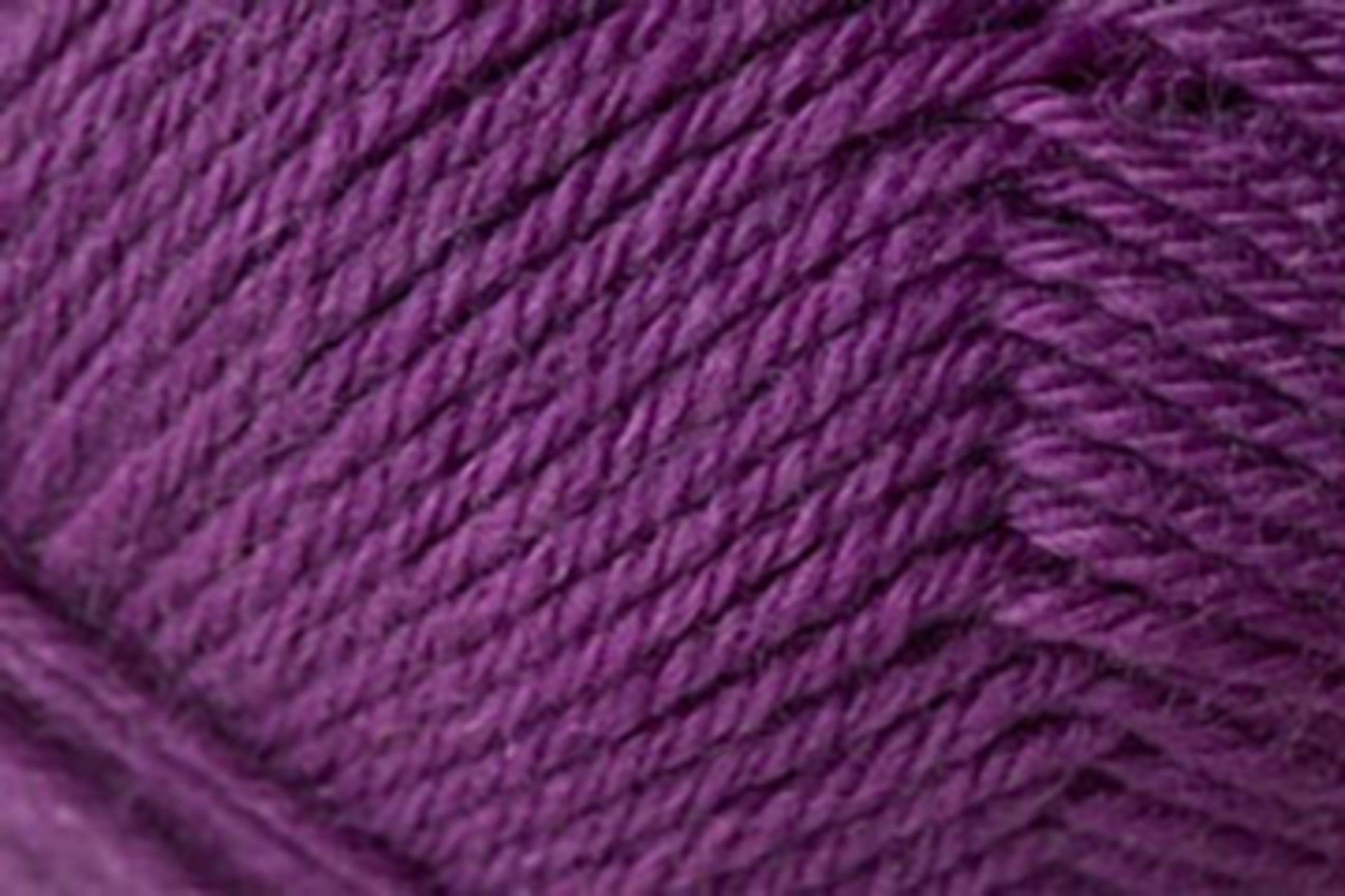 Close-up image of Jo Sharp Classic DK Wool by Kingfisher Yarn & Fibre, featuring a ball of rich, deep purple yarn with tightly wound fibers and visible texture. The image highlights the strands' thickness and twist, showcasing the yarn's smooth and even surface. Made from premium grade wool.