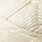 A close-up image of Jo Sharp Classic DK Wool by Kingfisher Yarn & Fibre. The tightly wound cream-colored strands reveal the texture and thickness of the premium-grade wool fibers, showcasing their soft and smooth appearance. The image captures the intricate details and natural warmth of this versatile DK gauge yarn.