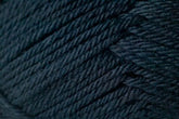 Close-up image of tightly wound dark blue yarn from Jo Sharp Classic DK Wool by Kingfisher Yarn & Fibre, showcasing the texture and individual strands of the fibers. This wool appears thick and soft with a slightly glossy finish. The image captures the intricate details of the weave and slight variations in color, highlighting its versatile DK gauge.