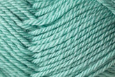 A close-up view of soft, teal-colored yarn made from Jo Sharp Classic DK Wool by Kingfisher Yarn & Fibre. The yarn is tightly wound, showcasing a slightly fuzzy texture and twisted strands. The vibrant color and detailed texture are the main focal points of the image.