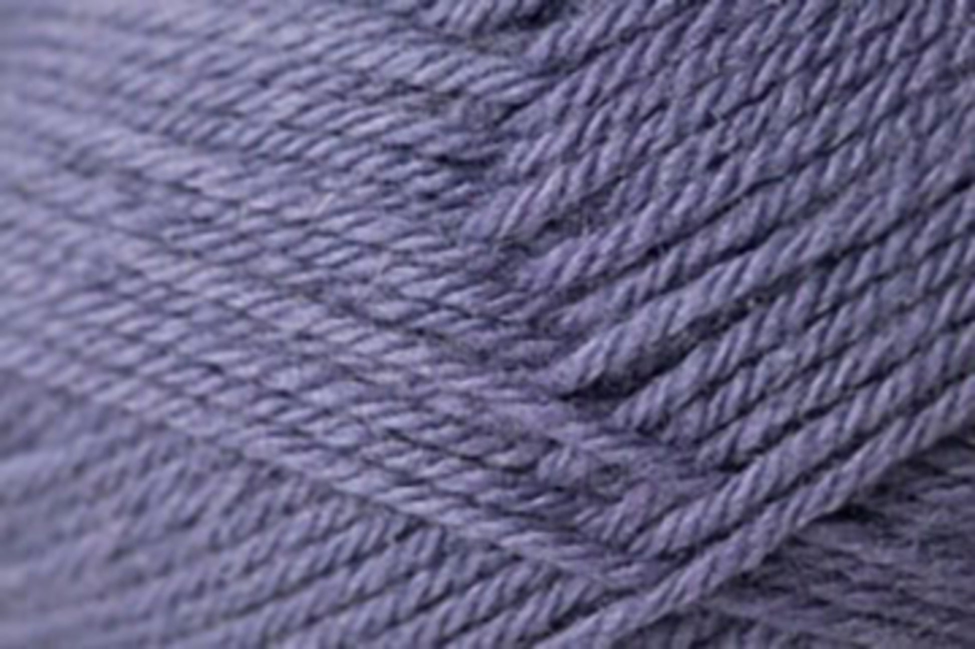 Close-up of a ball of lavender-colored Jo Sharp Classic DK Wool from Kingfisher Yarn & Fibre with tightly wound fibers, showcasing its soft texture and slight sheen. The image highlights the detailed strands and the overall smoothness of this versatile DK gauge yarn, making it ideal for knitting or crocheting projects.