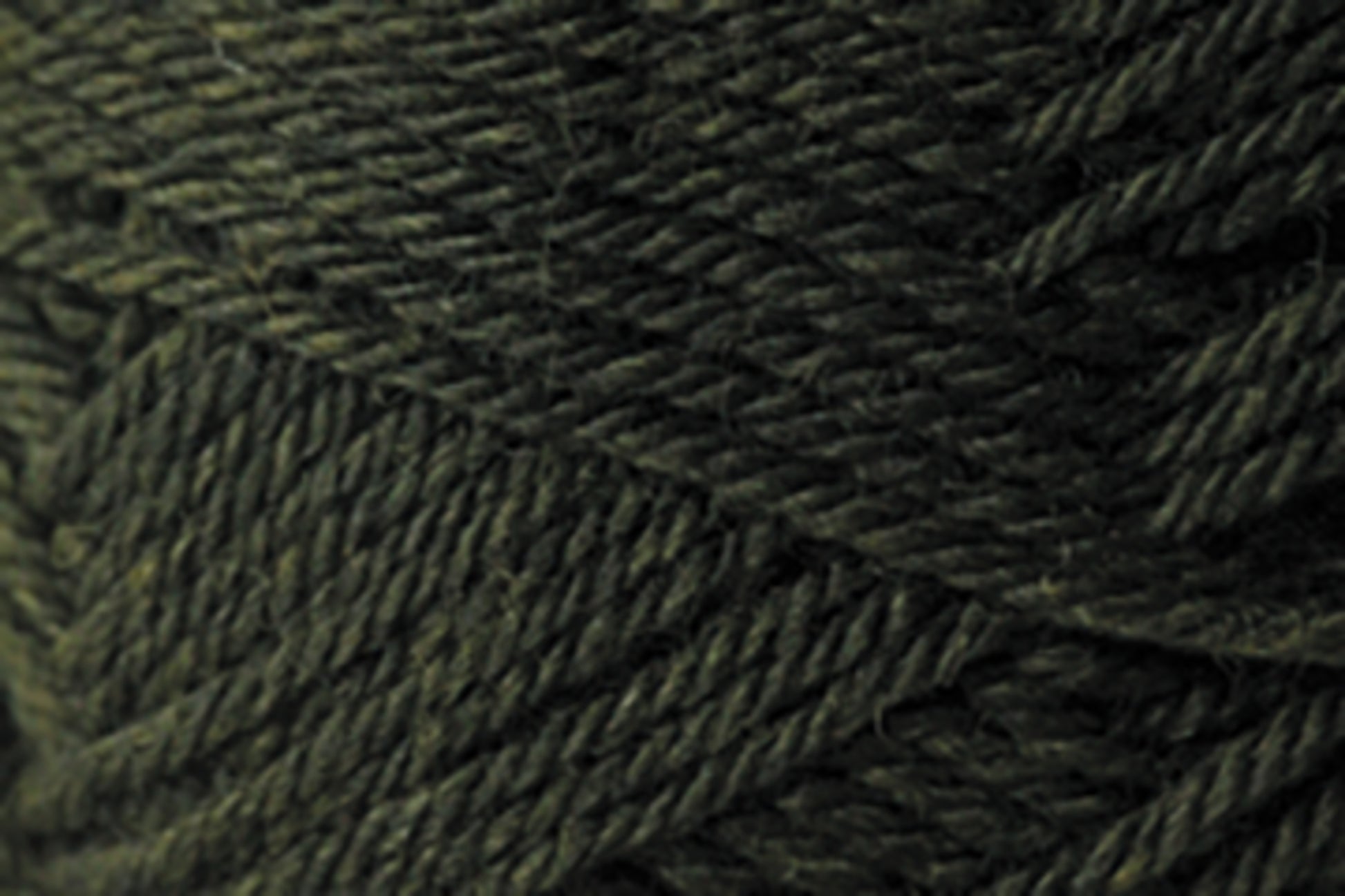 Close-up image of Jo Sharp Classic DK Wool in dark green by Kingfisher Yarn & Fibre, showcasing its detailed texture and intricate strands. The premium-grade wool appears thick and slightly coarse, with tightly woven fibers.