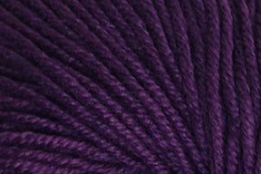 Close-up view of deep purple yarn. The fibers are tightly wound in a consistent spiral pattern, creating a soft, textured surface. Crafted from Jo Sharp Mulberry Silk Georgette by Kingfisher Yarn & Fibre, the rich and dark purple color gives the yarn a luxurious appearance, perfect for heirloom items.