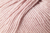 Close-up image of a ball of Jo Sharp Mulberry Silk Georgette yarn by Kingfisher Yarn & Fibre, revealing the texture and details of the tightly wound pale pink strands. The yarn appears soft and smooth, suggesting a blend that includes Extrafine Merino Wool. The strands are neatly coiled and ready for knitting or crocheting heirloom items.