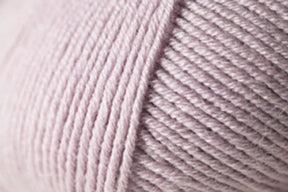 Close-up image of a ball of Jo Sharp Mulberry Silk Georgette Yarn by Kingfisher Yarn & Fibre. The strands are neatly wound around each other, creating a textured, ribbed pattern that highlights the softness and gentle light pink color—perfect for crafting heirloom items.