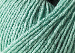 Close-up of soft, light teal yarn, showcasing its texture and tightly wound strands. The image highlights the yarn's smooth and slightly fuzzy surface, suggesting its suitability for knitting or crocheting cozy garments or heirloom items made from Jo Sharp Mulberry Silk Georgette Yarn by Kingfisher Yarn & Fibre.