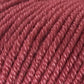 Close-up of a ball of Jo Sharp Mulberry Silk Georgette Yarn with a pinkish-red hue, crafted from soft Extrafine Merino Wool. The texture of the yarn fibers and individual strands are clearly visible, making it perfect for creating heirloom items by Kingfisher Yarn & Fibre.