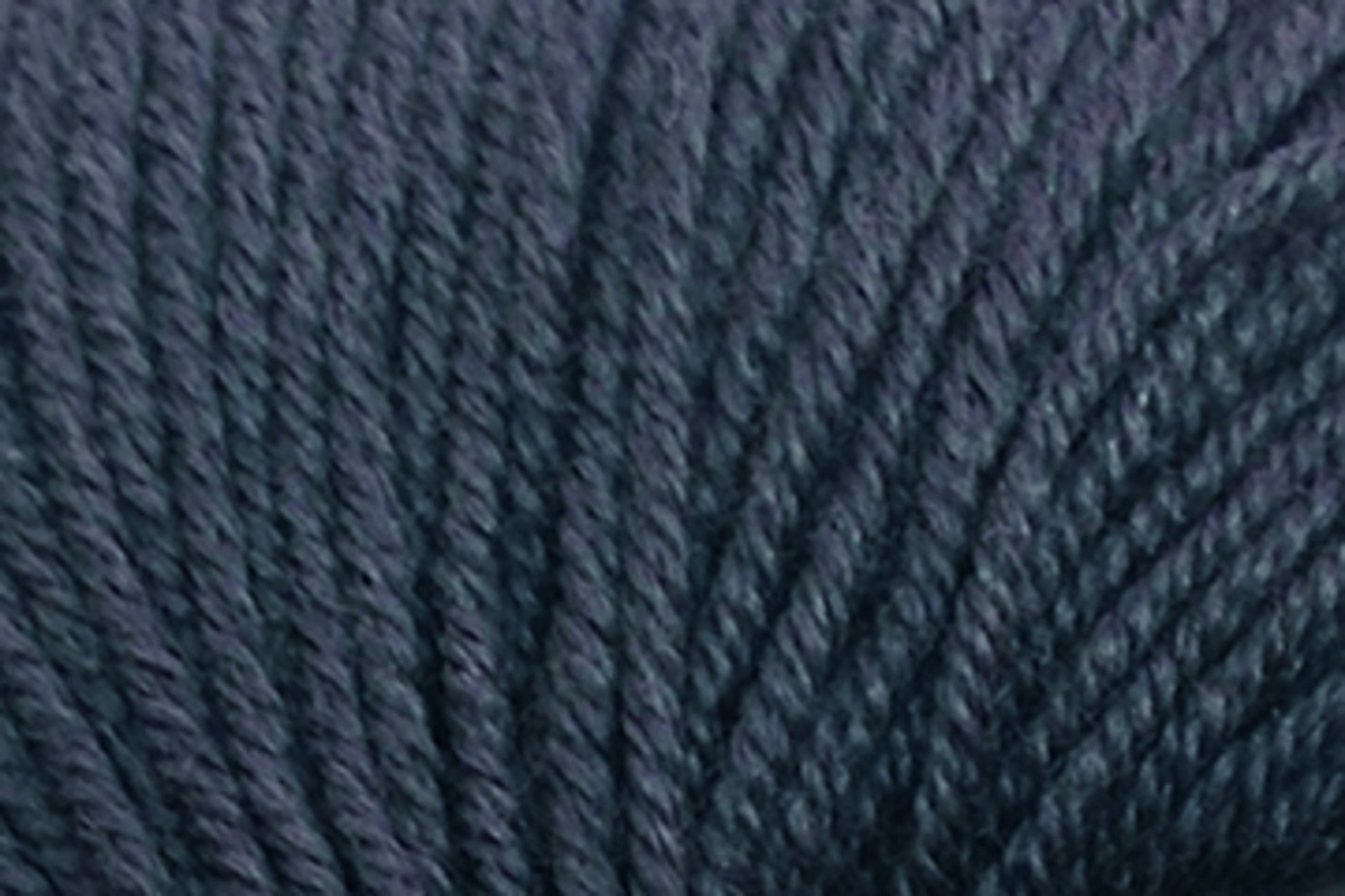 Close-up photograph of dark gray, slightly textured yarn. The fibers appear thick and tightly twisted, creating a consistent, smooth surface. Made from Extrafine Merino Wool, the yarn has a matte finish and the individual threads can be seen intertwining with one another.

Jo Sharp Mulberry Silk Georgette Yarn by Kingfisher Yarn & Fibre.