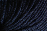 Close-up image of tightly coiled strands of dark blue Jo Sharp New Era Merino DK Superwash yarn from Kingfisher Yarn & Fibre, showcasing the texture and detail of the super soft, machine washable fibers.