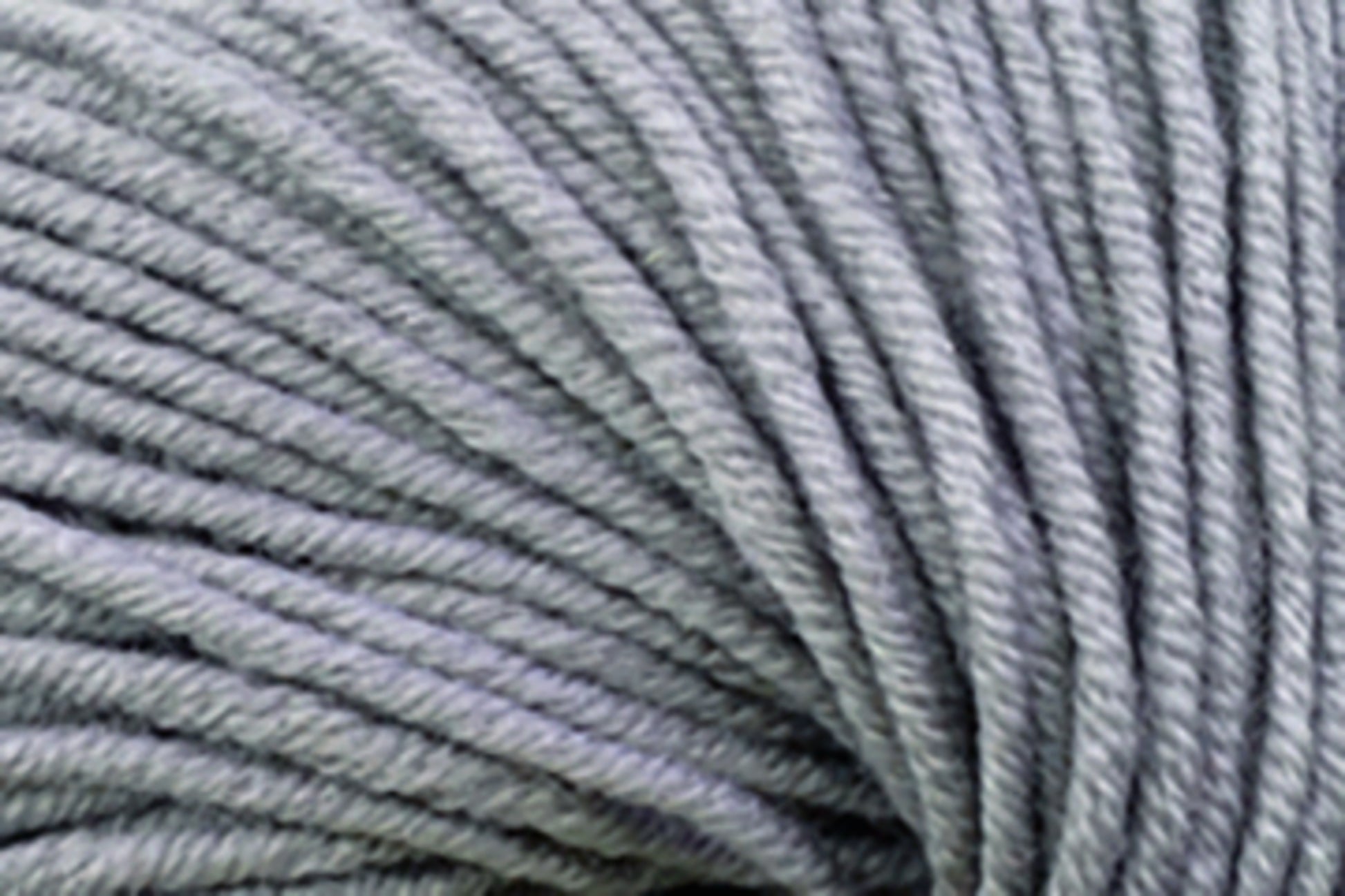 Close-up image of several strands of Jo Sharp New Era Merino DK Superwash yarn by Kingfisher Yarn & Fibre, displaying the super soft texture and details of the gray fibers—ideal for DK weight projects.