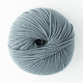 A ball of Jo Sharp New Era Merino DK Superwash yarn from Kingfisher Yarn & Fibre is neatly wound and placed against a white background. This baby-safe, super soft light grey yarn appears thick and gentle, perfect for DK weight projects like knitting or crocheting. Plus, it's machine washable for added convenience.