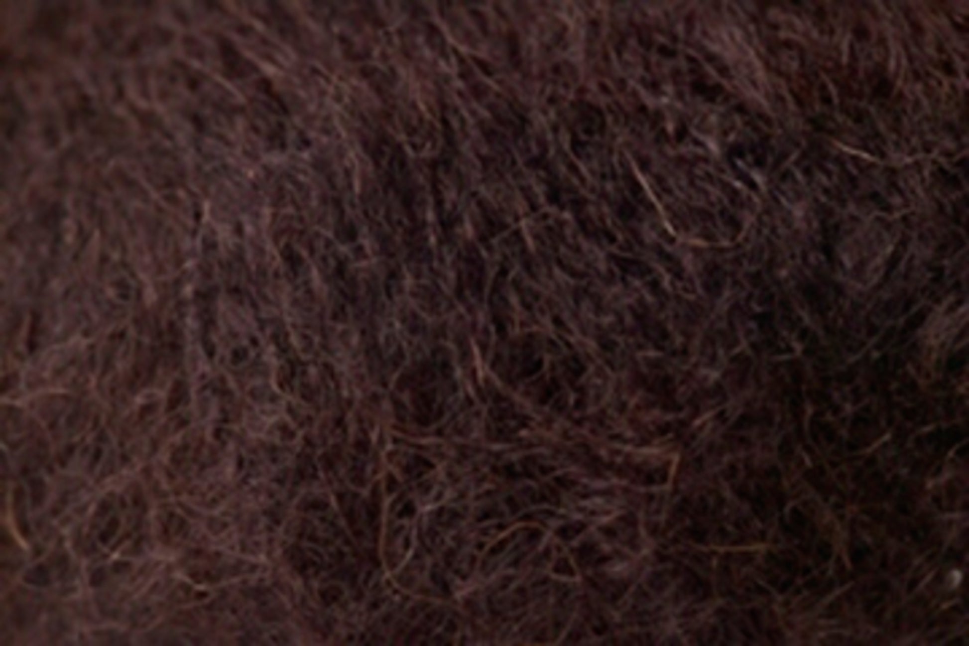 Close-up view of Jo Sharp Rare Comfort Kid Mohair from Kingfisher Yarn & Fibre, showcasing a dark brown, coarse, and curly textured material. The texture appears dense and fibrous, creating a rugged yet surprisingly soft appearance.