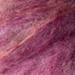 Close-up of fluffy, textured pink and purple Kid Mohair fibers from the Jo Sharp Rare Comfort collection by Kingfisher Yarn & Fibre, intertwined to showcase a range of shades with a slightly fuzzy appearance. Perfect for crafting airy sweaters that epitomize rare comfort.