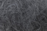 Close-up of a tangled mass of Jo Sharp Rare Comfort Kid Mohair fibers from Kingfisher Yarn & Fibre. The texture appears coarse and intertwined, resembling a bundle of hair or fine threads. The image evokes a sense of disarray, with various strands overlapping in an unkempt manner, much like the cozy chaos one might find in airy sweaters.