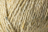 Close-up of a ball of luxurious yarn with rich tweed highlights, featuring slight variations in color and texture. Showcasing the soft, twisted fibers and natural appearance, the Kingfisher Yarn & Fibre's Jo Sharp Silkroad Aran Tweed appears thick and perfect for knitting or crocheting warm, cozy items.