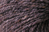 Close-up of a textured ball of Kingfisher Yarn & Fibre's Jo Sharp Silkroad Aran Tweed in varying shades of purple and grey. The strands are tightly spun, showcasing the natural fibers and slight color variations. Rich tweed highlights emphasize the intricate details and softness of this luxurious yarn.