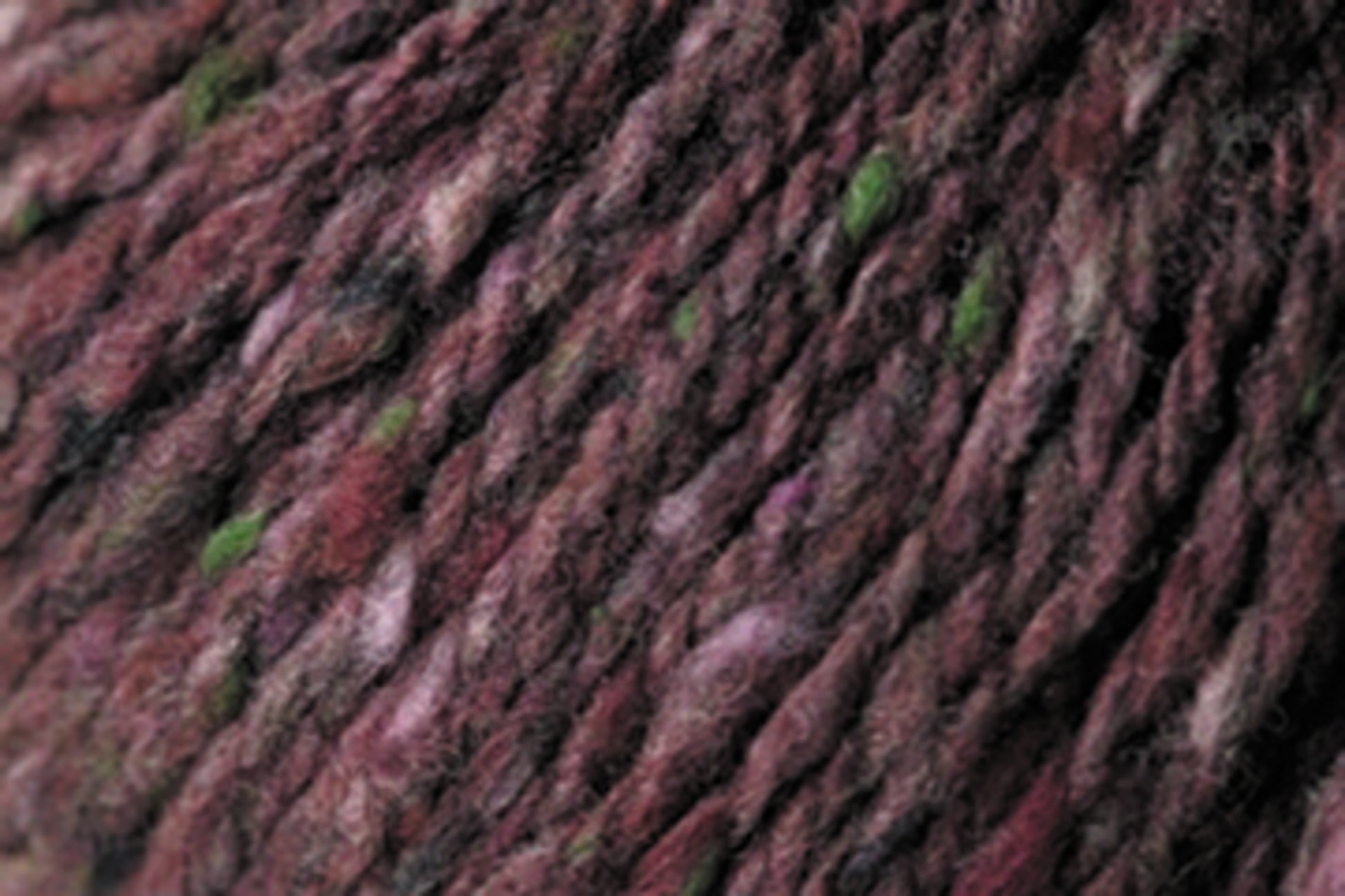 Close-up image of a luxurious yarn in shades of maroon, purple, pink, and hints of green. The fibers are intertwined, creating a variegated and slightly fuzzy appearance with rich tweed highlights reminiscent of Kingfisher Yarn & Fibre's Jo Sharp Silkroad Aran Tweed.