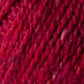 Close-up of a swatch of thick, red yarn. This luxurious fiber, from Kingfisher Yarn & Fibre, showcases the rich red color and subtle variations in shade that create texture and depth. The fibers appear soft and slightly fuzzy, with a tightly twisted structure reminiscent of Jo Sharp Silkroad Aran Tweed.